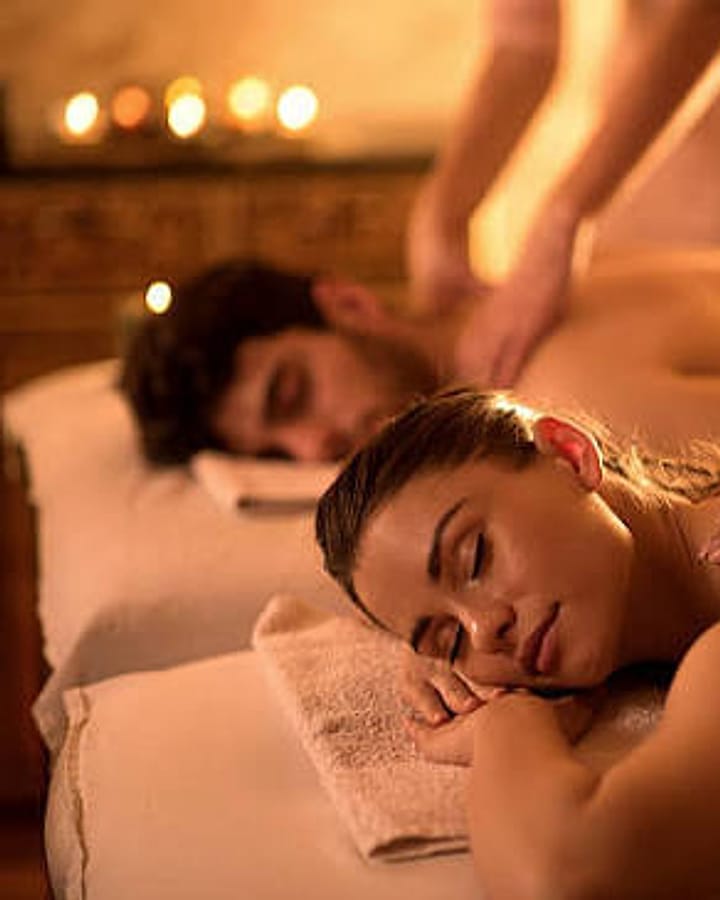 Couple relaxing side by side during a massage in a private room